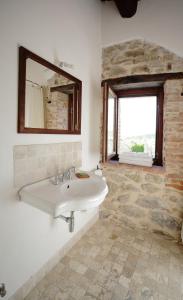 a bathroom with a sink and a mirror and a window at La Casa Di Piandelbello in San Venanzo