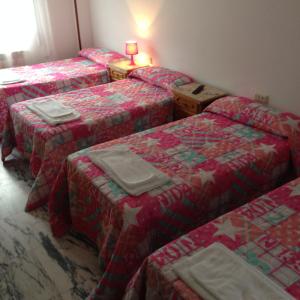 um grupo de quatro camas num quarto em Pensión Glorioso II em Picaraña