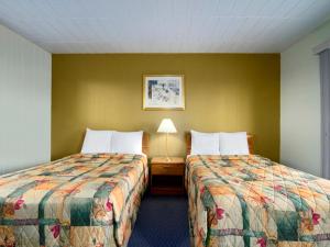 una habitación de hotel con 2 camas y una lámpara en Save Inn en Kincardine