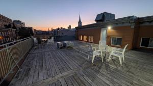 een terras met stoelen en een grill op een gebouw bij Refuge Urbain Quebec - Loft Bonséjours in Québec