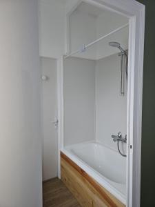 a white bath tub in a bathroom with a shower at Maison Aéroport Bourges in Bourges +3 photos