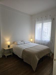 ブールジュにあるMaison Aéroport Bourgesのベッドと窓のある白い寝室 +3枚の写真