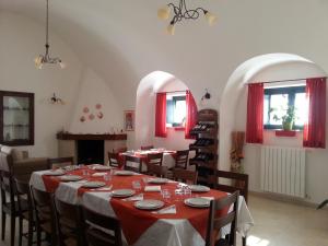 una sala da pranzo con tavolo, sedie e finestre di La Ferula Bed&Pool a Santeramo in Colle
