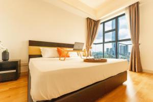 a bedroom with a bed with a laptop on it at Suasana by TPL - Bukit Bintang KLCC in Kuala Lumpur +20 photos