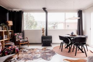 un salon avec une table et des chaises et une fenêtre dans l'établissement HOBART 3 Bedroom, à West Hobart