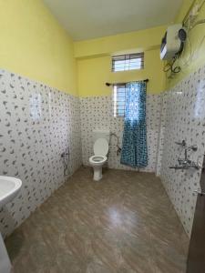 a bathroom with a toilet and a sink and a window at The rolling hills Kaziranga in Hatikhuli