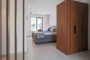 a bedroom with a bed and a wooden cabinet at Luxe villa Santa Rosalia in Torre-Pacheco +13 photos