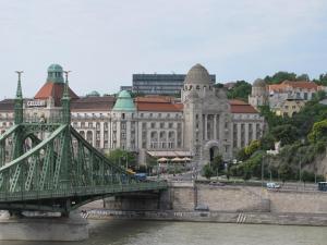un ponte su un fiume di fronte a un grande edificio di Empire of Liberty a Budapest