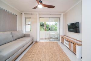 Una sala de estar con un sofá y un televisor de pantalla plana. en Seaside Serenity, en Ballito