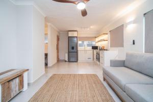 Una sala de estar con un sofá y una cocina. en Seaside Serenity, en Ballito