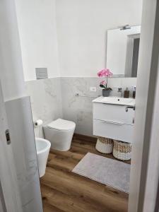 a bathroom with a toilet and a sink and a mirror at Casa Sonia Apartment Mondello in Mondello