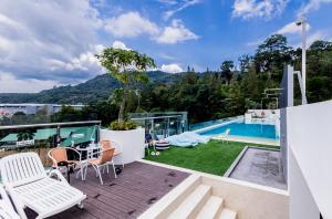 a patio with a table and chairs and a pool at FantaSea condo Kamala 204 in Kamala Beach