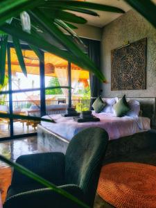 a bedroom with a bed in a room with windows at SANA Koh Phangan in Salad Beach