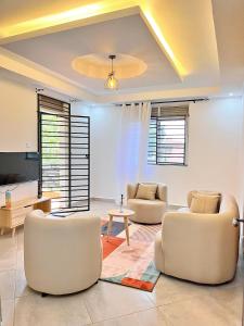 a living room with two chairs and a table at Apartment unit-Luxury in Kampala +22 photos