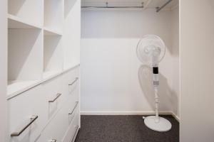 a white closet with a white fan in a room at Bridge Beach House Central Barwon Heads Sleeps 12 Walk everywhere Accessible lower level bedroom and bathroom in Barwon Heads +63 photos