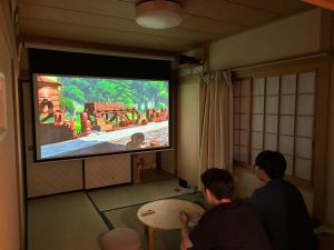 a group of people in a room watching a television at Villa Foresta TERU in Nasu
