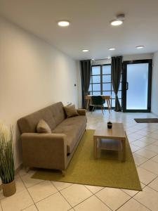 een woonkamer met een bank en een salontafel bij Là cachette in Remiremont +2 foto's