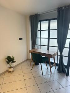 een eetkamer met een tafel en een raam bij Là cachette in Remiremont