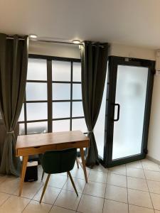 een tafel en een stoel voor een raam bij Là cachette in Remiremont