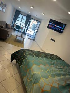 een slaapkamer met een bed en een woonkamer bij Là cachette in Remiremont