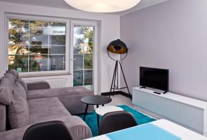 a living room with a couch and a television at Haller House Apartamenty in Władysławowo