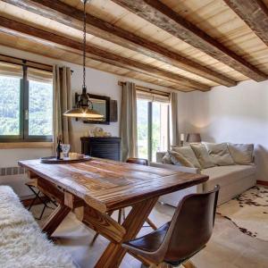 ein Wohnzimmer mit einem Holztisch und einem Sofa in der Unterkunft L'Ours Blanc Lodge in Le Biot