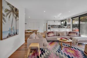 a living room with a couch and a table at Bridge Beach House Central Barwon Heads Sleeps 12 Walk everywhere Accessible lower level bedroom and bathroom in Barwon Heads
