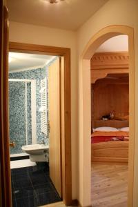 a bathroom with a sink and a bed in a room at Hotel Garni La Roccia in Andalo