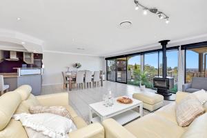 a living room with a couch and a table at Oasis at Salamander Bay in Salamander Bay