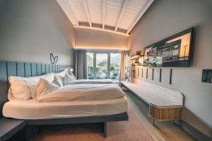 een slaapkamer met een groot bed en een raam bij HOP Apartments & Suites in Interlaken