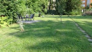 a garden with a table and chairs in the grass at Kempelen kúria in Esztergom +5 photos