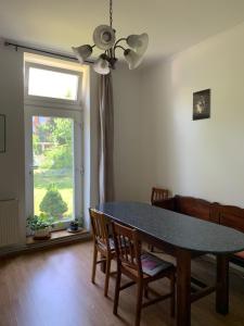 a dining room with a table and chairs and a window at Kempelen kúria in Esztergom