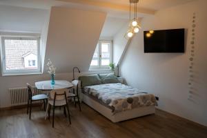 a bedroom with a bed and a table and a tv at Talvera Dream in Bolzano