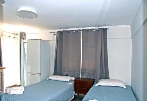 two beds in a small room with a window at Skyline Loft in Mytilene