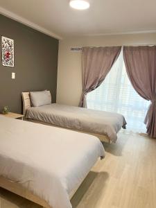 a bedroom with two beds and a window at hotel gala city Izumizaki 5 mins to Kokusai Street 24 square meters room in Naha