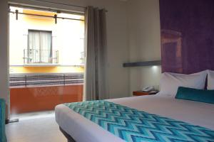 Un dormitorio con una cama y una ventana con balcón. en Orizaba Inn, en Orizaba 37 fotos más