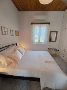 a large white bed in a bedroom with a window at "Villa Kanella"Sea View Hydra Kamini malouholidays in Hydra