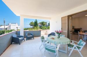 a patio with a table and chairs and a view of the ocean at Villa Saracena in Castellammare del Golfo