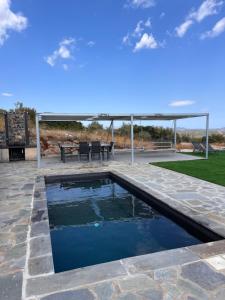 a swimming pool in a patio with a table and a grill at Modern Stone Villas with Swimming Pool in Aliveri