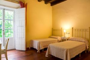 two beds in a room with yellow walls at Apartamento junto a la catedral in Seville