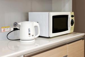 a microwave sitting on a counter next to a coffee maker at SunRise STAY Haruna in Tokyo