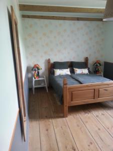 a bedroom with a bed and a wooden floor at La Maison Des Badons in Saint-Basile