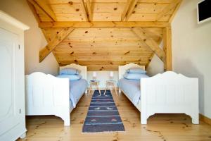 two beds in a room with a wooden ceiling at Siedlisko Grabinowo k/Olsztyna in Olsztyn