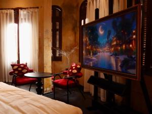 a room with a tv and a bed and a table at DEMO Inn & Ine - Poetic Studio Stay by ATV in Hanoi