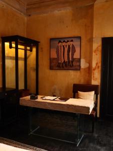 a table in a room with a painting on the wall at DEMO Inn & Ine - Poetic Studio Stay by ATV in Hanoi