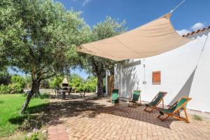 a patio with chairs and a tent next to a building at CHARMING HIDEAWAY Self check-in - Accesso autonomo in Alghero