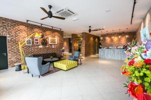 a lobby with a brick wall and a couch and chairs at Athome Boutique Hotel in Bintulu