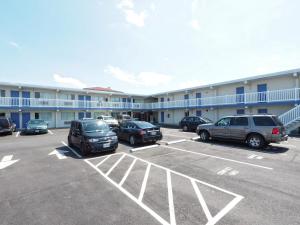 un estacionamiento con autos estacionados frente a un motel en Seashire Inn & Suites, en Virginia Beach