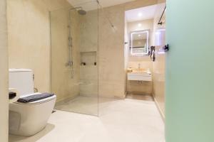 a bathroom with a toilet and a glass shower at Alkida Luxury Rooms Tolo in Tolo +26 photos