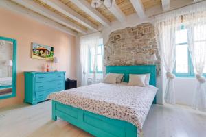 Un dormitorio con una cama azul y una pared de ladrillo en Heritage Hotel Chersin en Fažana